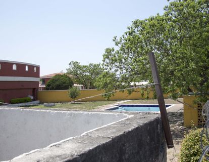 El área de jardín y de alberca donde está situada la cisterna en la que apareció el cuerpo de Debanhi Escobar. A la izquierda, el restaurante El Botanero, cerrado de forma permanente, y al fondo, el muro que separa esta zona de la recepción del hotel.